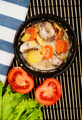 Beef meat stewed with potatoes, carrots and spices in ceramic pot