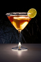 Cocktail in martini glass with sugar edges and slice of lime