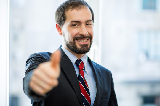 Male manager thumbs up on white background