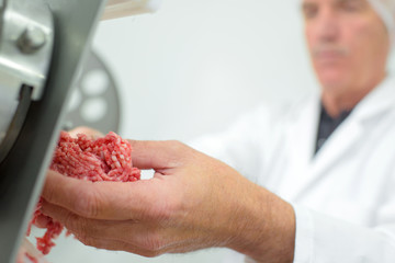 Closeup of butcher mincing meat