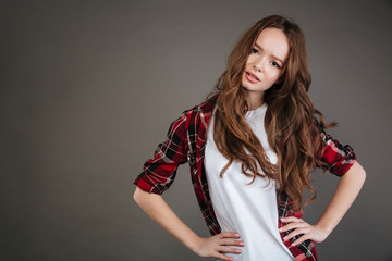 Unhappy pretty young woman standing with hands on waist