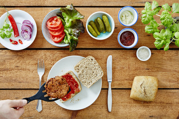 delicious vegan sandwich hand adding patty