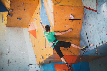 Fototapeta na wymiar man climbs a route in a training room, competition