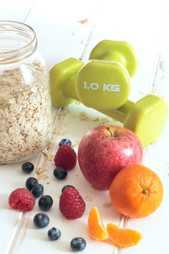 Healthy Oat muffin with fruits and Dumbbells. Diet concept