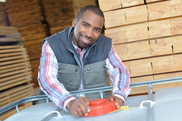 worker with heaps of wood in the background