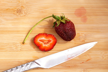 Lonely strawberry on a chopping board
