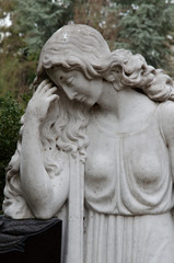 trauernde frauen-steinskulptur lehnt an einem grabstein