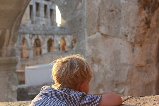 small boy looking at ancient walls in roman arena pula croatia