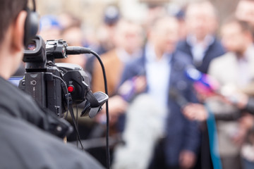 Filming an media event with a video camera. News conference.