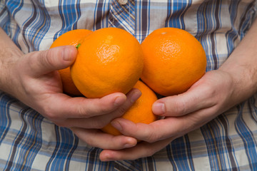 Oranges in the man's hands. Healthy eating and lifestyle.