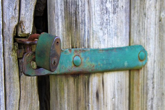 old metall padlock on a locked wooden door, no entry, shut out, bolted and barred, secret