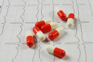 Pharmaceutical medicament, cure in container for health and cardiogram on white background.