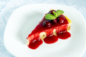 Homemade cherry cheesecake in white plate on light cloth napkin