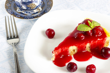 Homemade cherry cheesecake in white plate on light cloth napkin