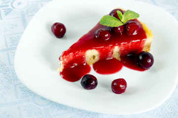 Homemade cherry cheesecake in white plate on light cloth napkin