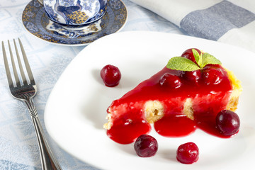 Homemade cherry cheesecake in white plate on light cloth napkin