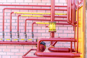 distributor gas pipes in a residential complex, the gas valve on a background of red brick wall