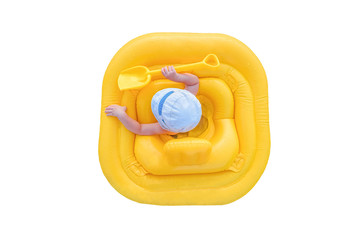 Baby in a yellow inflatable raft isolated on a white background. Small child in yellow rubber ring. View from the top.