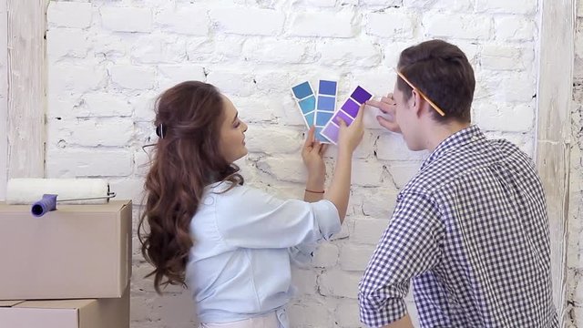 Young couple and color swatches to select a wall decoration