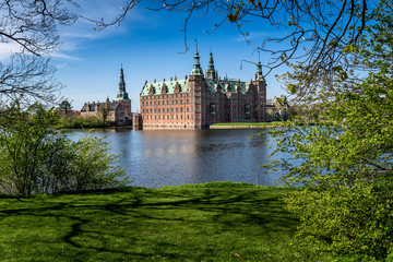 Morning sight of Frederiksborg Castle across the lake, settled in a town Hilerod, north-west of Copenhagen, Denmark