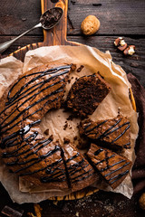 Chocolate brownie cake, dessert with nuts on dark background, top view