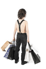 A curly-haired boy is standing with purchases back to the camera. White background.