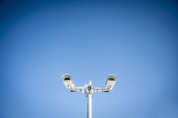Security cameras against blue sky