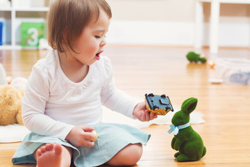 Happy toddler girl playing with toys