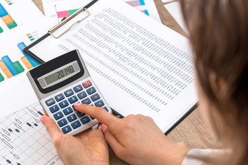 Woman calculate about expenses at office.