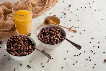 Chocolate flakes honey and orange juice for breakfast on a white background. Two portions.