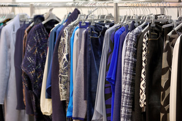 Row of clothes hanging in wardrobe or store