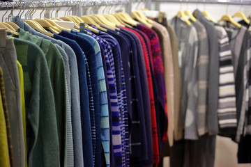 Row of clothes hanging in wardrobe or store