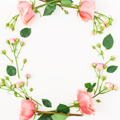 Round frame with pink roses and leaves on white background. Flat lay, top view. Floral background.