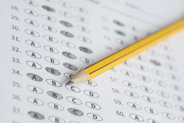 A pencil sitting on a test bubble sheet, optical form of an examination,Answer sheet with...