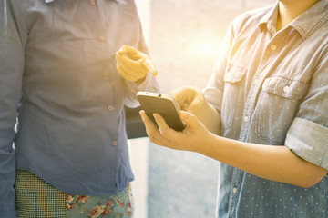 two colleagues businesswoman discussing data and digital tablet and computer laptop with smart phone with digital business strategy in modern loft office,selective focus,vintage color