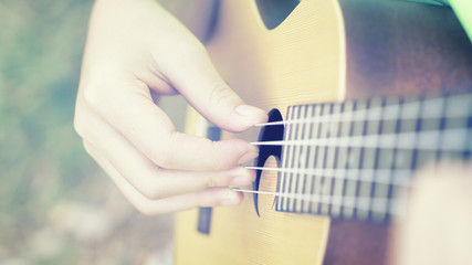 Fototapeta premium woman handicraft playing ukulele. Hands playing a musical instrument.relaxing and free people on Ukulele (mini guitar) at the park,sunset vintage tone,selective focus,copy space for advising