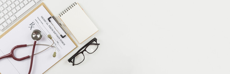 Wooden doctor desk,Doctor working,Hospital Workplace with notepad and keyboard,pen,glasses,and stethoscope,monitoring patient ,business ,healthcare and medical concept, with copy space for banner