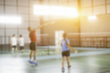  Blurred background of the shuttlecock and badminton courts with players competing in modern gym,vintage color