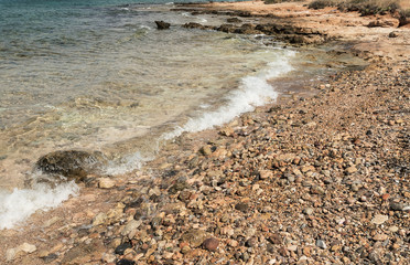 view of the sea shore with small pebbles