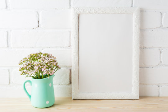 White frame mockup with soft pink flowers near exposed bricks