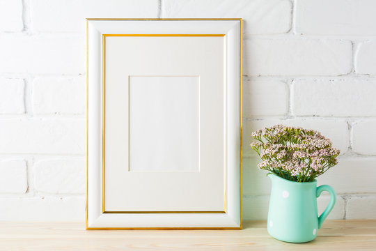 Gold decorated frame mockup with soft pink flowers and bricks