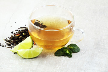Tea. Herbal tea. Mint leaf. Tea in a glass cup, mint leaves, dried tea, sliced lime. herbs on a slate plate in a restaurant or teahouse