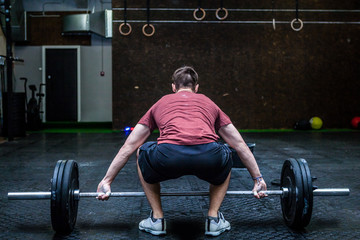 Young man with weight training equipment in sport gym