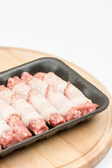 Homemade kebabs rolled in bacon on the wooden board