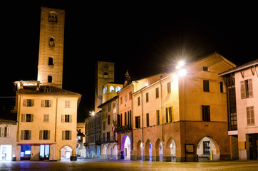 Fototapeta na wymiar Piazza Risorgimento and the medieval towers of via Cavour, one of the main street of the town center of Alba (Piedmont, Italy) at night