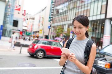 Fototapeta premium Woman using cellphone in Fukuoka city