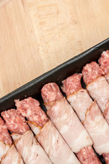 Homemade kebabs rolled in bacon on the wooden board