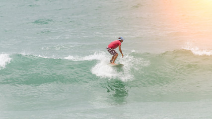 Surfer jumping above a wave on the North Shore of Oahu, Hawaii