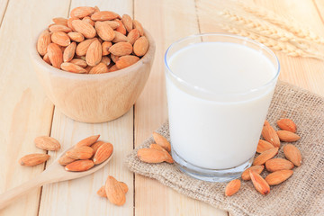 Almond milk in glass with almonds on wooden table, Close up