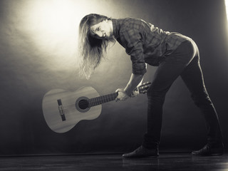 Rock musician destroys his guitar.